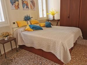 a bedroom with a bed with yellow and blue pillows at CA FOSCARINI 1 in Venice