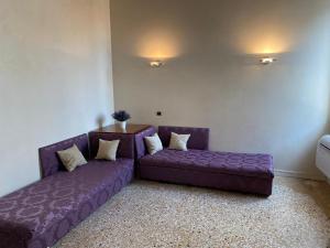 a living room with a purple couch and a table at CA FOSCARINI 1 in Venice