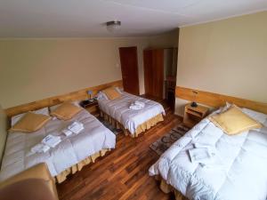 a hotel room with two beds with towels on them at HOTEL GLACIARES in Puerto Natales
