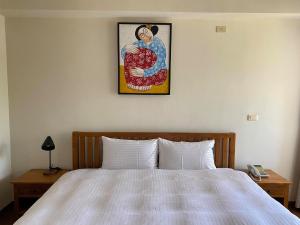um quarto com uma cama e uma fotografia na parede em Mamalulu Hostel em Kenting