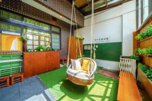 eine Veranda mit einem Schaukelstuhl in einem Gebäude in der Unterkunft 木Box田妍山色 in Jiaoxi