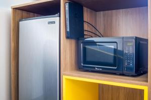 a microwave and a refrigerator sitting on a shelf at Days Inn by Wyndham Red Bluff in Red Bluff