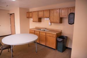 a kitchen with a white table and a sink at Wagner Lakeside Motel in Wagner