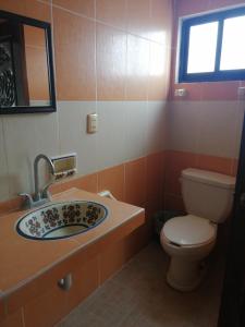een badkamer met een wastafel en een toilet bij Hotel Villa Palmeras in Tecolutla