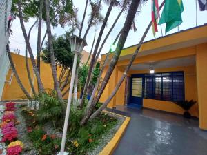 a building with palm trees and flowers in front of it at Tropical Mooca in Sao Paulo