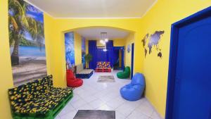 um corredor com um quarto com paredes amarelas e cadeiras coloridas em Tropical Mooca em São Paulo
