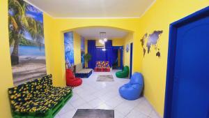 a hallway with a room with yellow walls and colorful chairs at Tropical Mooca in Sao Paulo