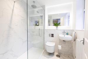 een badkamer met een douche, een toilet en een wastafel bij Stunning City Centre House With Hot Tub & Cinema Room in Norwich