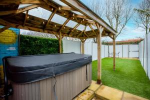 a pergola with a bench in a backyard at Stunning City Centre House With Hot Tub & Cinema Room in Norwich