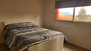 a bed in a room with a window at UBUNTU in Concepción del Uruguay