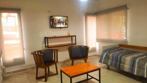 a bedroom with a bed and two chairs and a table at UBUNTU in Concepción del Uruguay