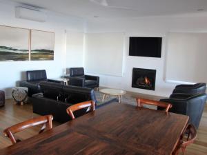 a room with a table and chairs and a fireplace at Wisharts Landing in Port Fairy