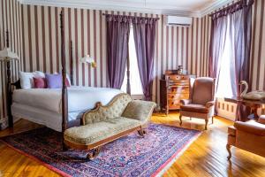 1 dormitorio con 1 cama y 1 silla en Queen Anne Inn, en Annapolis Royal