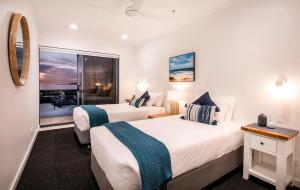 a hotel room with two beds and a window at Watercolours on Marina in Glenelg