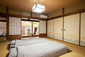 a bedroom with a bed in a room with windows at Hostel Ayame in Kyoto