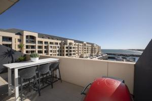 a balcony with a table and chairs and some buildings at Watercolours on Marina in Glenelg