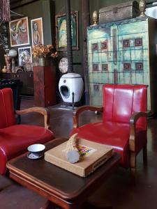a living room with a red chair and a table at Calvinia Magic Garden in Calvinia