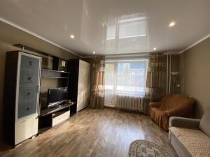 a living room with a couch and a television at Dekabrist apartment at Ugdanskaya 8 in Chita