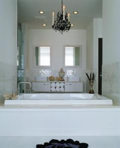 baño con bañera blanca y lámpara de araña en Bungalow Hotel en Long Branch