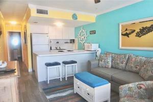 uma sala de estar com um sofá e uma cozinha em Treasure Island 1BR Beach condo with Gulf View em St. Pete Beach
