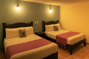 a hotel room with two beds and two lamps at VO´E in San Cristóbal de Las Casas