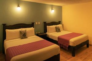 a hotel room with two beds and two lamps at VO&acute;E in San Crist&oacute;bal de Las Casas