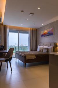 1 dormitorio con cama grande y ventana grande en AR Suites Jewels Royale - Koregaon Park NX en Pune