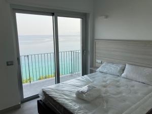 een slaapkamer met een bed en een groot raam bij Residenza Timpa Janca in Vibo Valentia Marina