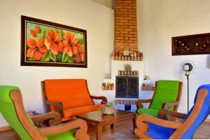 un soggiorno con sedie, tavolo e quadro di Casa Jericó Zapatoca a Zapatoca