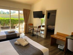 una camera d'albergo con due letti e una televisione di Emerald Explorers Inn a Emerald