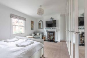 Dormitorio blanco con cama y chimenea en Windsor Town Centre Victorian townhouse sleeps 6 en Windsor