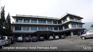 un edificio con auto parcheggiate di fronte di Hotel permata alam a Bogor