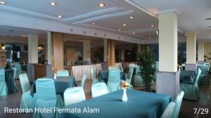 una sala banchetti con tavoli blu e sedie bianche di Hotel permata alam a Bogor