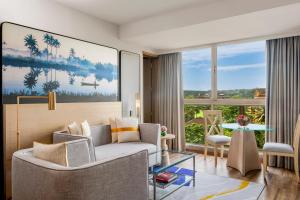 a living room with a couch and a table at Vivanta Goa, Miramar in Panaji