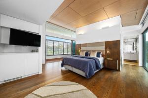 ヌーサヴィルにあるModern Riverview Escape with Private Poolのベッドと薄型テレビのある寝室 +15枚の写真