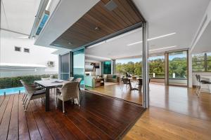 ヌーサヴィルにあるModern Riverview Escape with Private Poolのテーブルと椅子のあるダイニングルームとリビングルーム