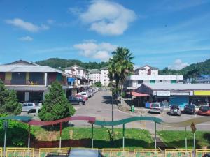 a city street with cars parked in a parking lot at Lodge 88 (1) in Ranau