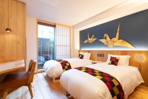 a bedroom with two beds and a window at Hotel Kanazawa Zoushi in Kanazawa