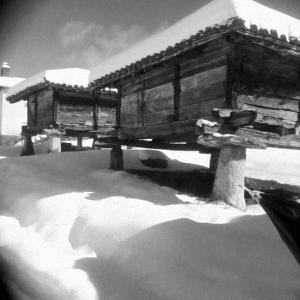 Cabaña de madera con nieve en el suelo en Los Tres Hórreos, en Felechas