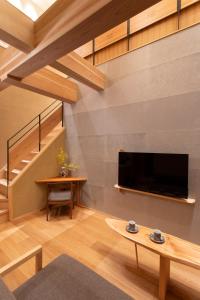 a living room with a large television and a table at Hotel Kanazawa Zoushi in Kanazawa