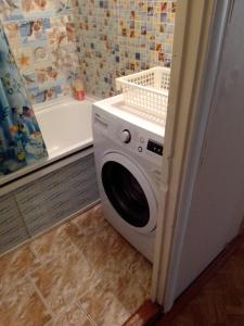 ヴォロネジにあるНа сутки рядом с М - 4 Воронеж Перевёрткина 31のバスルーム(バスタブの隣)の洗濯機