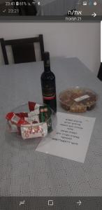 eine Flasche Wein und ein Teller mit Essen auf dem Tisch in der Unterkunft אירוח ברמה אחרת in Tiberias