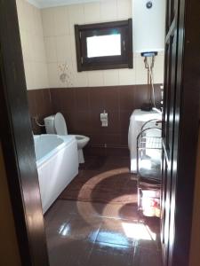 ein Badezimmer mit einer Badewanne, einem WC und einem Waschbecken in der Unterkunft Lotus chalet in Borzont