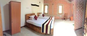 a bedroom with a bed and a brick wall at The Hideaway in Kurunegala +57 photos