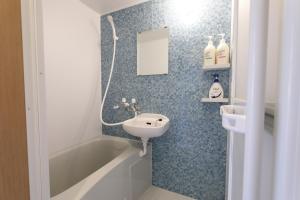 a bathroom with a sink and a bath tub and a sink at AQA ART 江の島 in Fujisawa