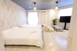 a bedroom with two beds and a flat screen tv at AQA ART 江の島 in Fujisawa