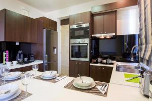 a kitchen with a table with plates and wine glasses at Rhodes Central Suite in Rhodes Town