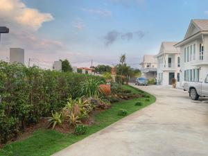 a residential street with houses and a driveway at Bannsukta in Na Jomtien