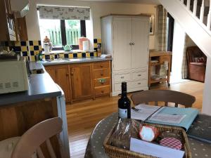 a kitchen with a table with a bottle of wine at Oak Cottage in Llandysul
