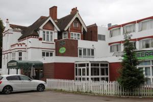 a white car parked in front of a building at Hylands Hotel in Coventry